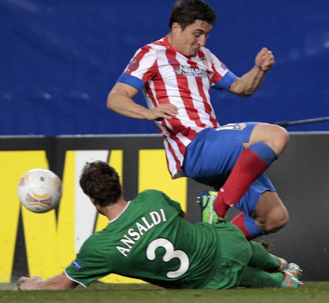 El centrocampista uruguayo del Atlético de Madrid Cristian Rodríguez pelea un balón con el defensa argentino del Rubin Kazan Cristian Ansaldi, durante el partido de ida de dieciseisavos de final de la Liga Europa de fútbol que se disputa en el estadio Vic