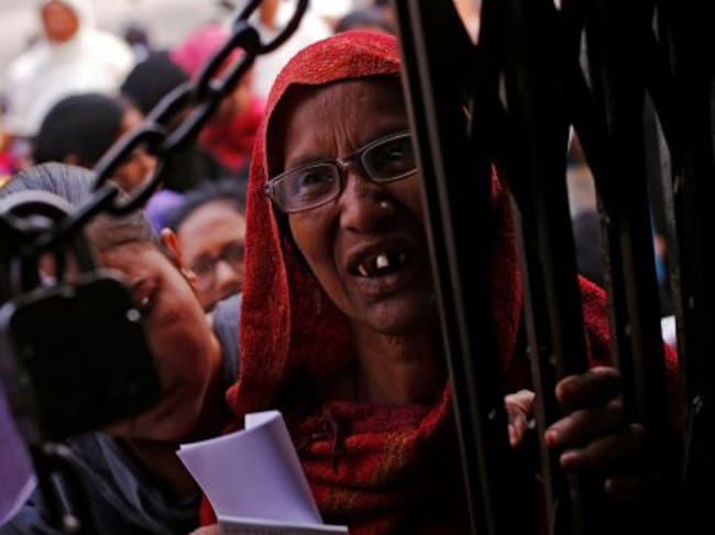Una mujer, en la puerta de una entidad bancaria de Kanpur.