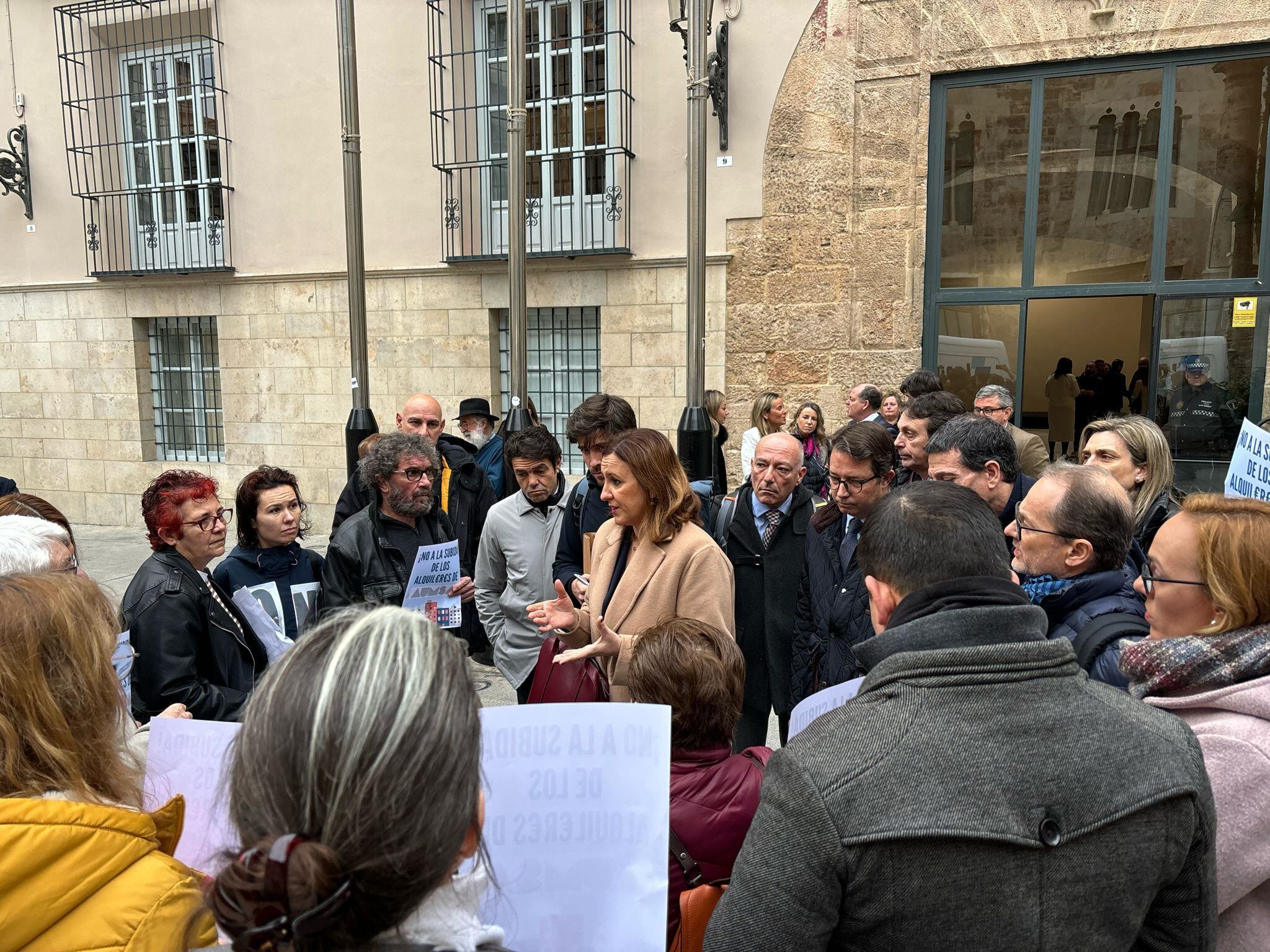 La alcaldesa María José Catalá dialoga con algunos de los inquilinos de Aumsa a las puertas de la Diputación de València, donde se celebra el pleno del Ayuntamiento