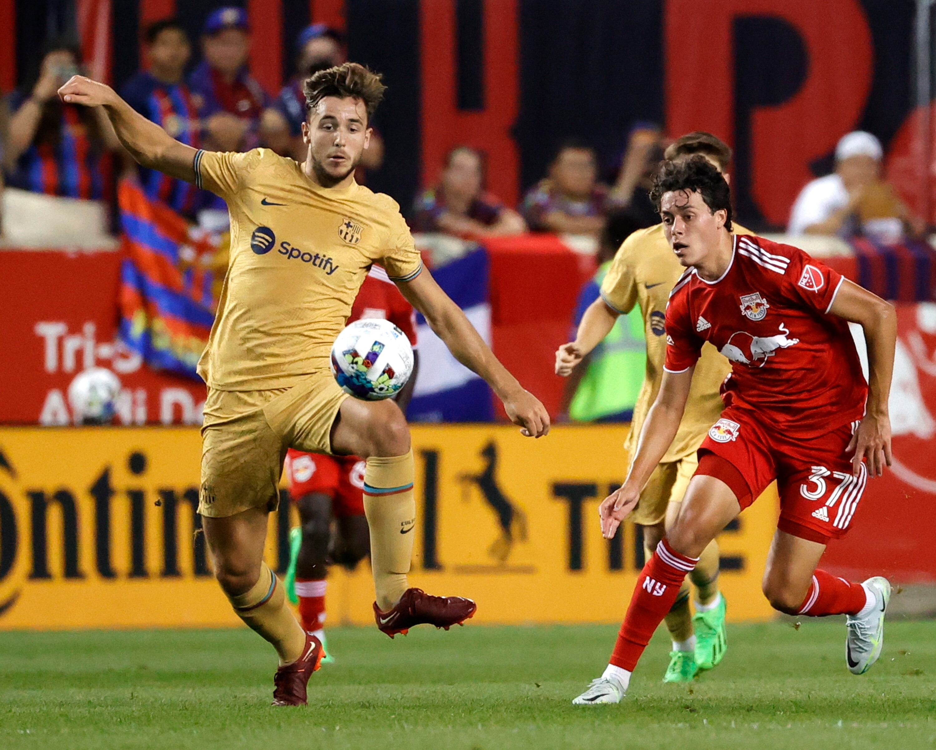 Nico Gonzalez dribbles the ball up field past a defending New York Red Bulls midfielder Caden Clark  during the second half of the MLS soccer friendly match between the FC Barcelona and the New York Red Bulls at Red Bulls Arena in Harrison, New Jersey, USA, 30 July 2022. (Futbol, Amistoso, Estados Unidos, Nueva York) EFE/EPA/JASON SZENES