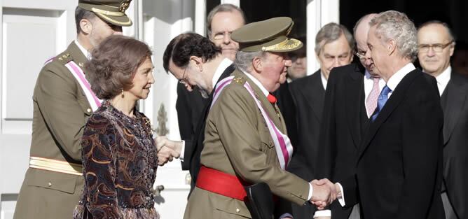 El Rey Juan Carlos, junto a la Reina Sofía y los Príncipes de Asturias, ha sido recibido por el presidente del Gobierno, Mariano Rajoy (3i), y el ministro de Defensa, Pedro Morenés (d), cerca de la puerta del Palacio Real que se abre a la Plaza de la Arme