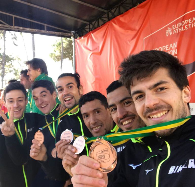 Javi García del Barrio haciendo el signo de la victoria con sus compañeros en el podio