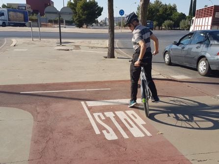 Justo López ante una señal de STOP en una intersección de dos tramos de carril bici