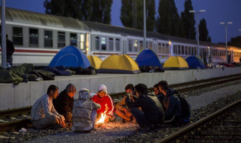 Refugiados entran en calor junto a una hoguera en la estación ferroviaria de Beli Manastir, al noreste de Croacia.