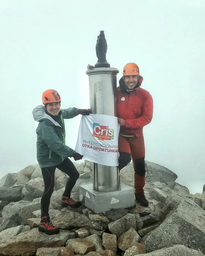 Pepe Monge, paciente oncológico y el doctor Joaquín Martínez, en el pico Aneto con la bandera de la Fundación CRIS contra el cáncer