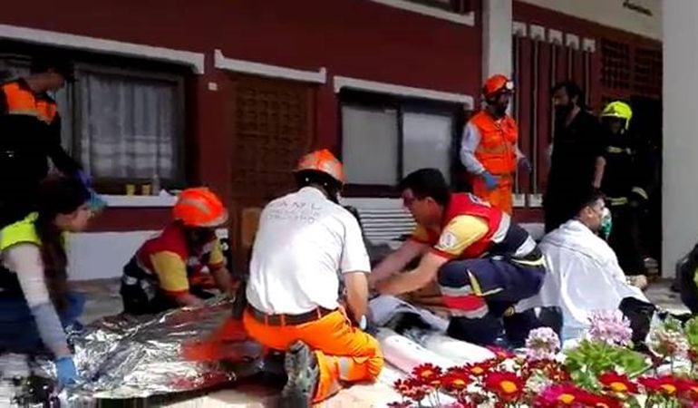 Los bomberos atienden a los vecinos afectados por el incendio en la urbanización La Chicharra, de la Albufereta, en el fuego que se declaró el 25 de abril de 2017.