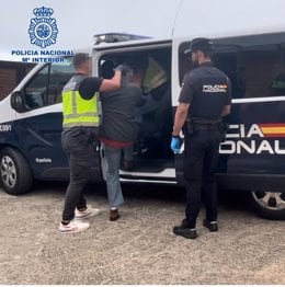 Agentes de la Policía Nacional introducen al detenido en un vehículo policial