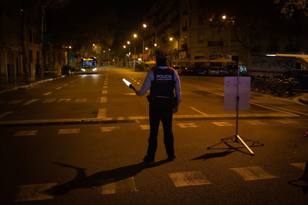 Archivo - Un mosso d&#039;Esquadra colabora en un control durante el toque de queda impuesto por la crisis sanitaria en Barcelona.