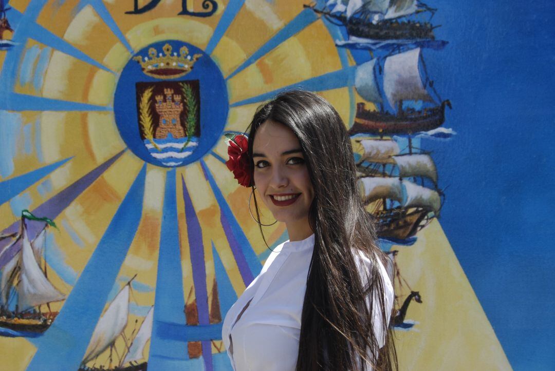 Una joven posa frente a la portada de una de las casetas del recinto ferial en Algeciras.