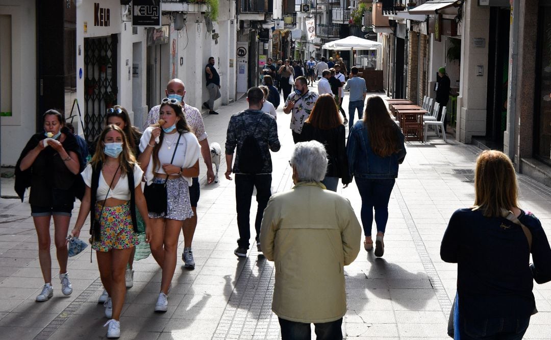 Varias personas caminan por la calle.