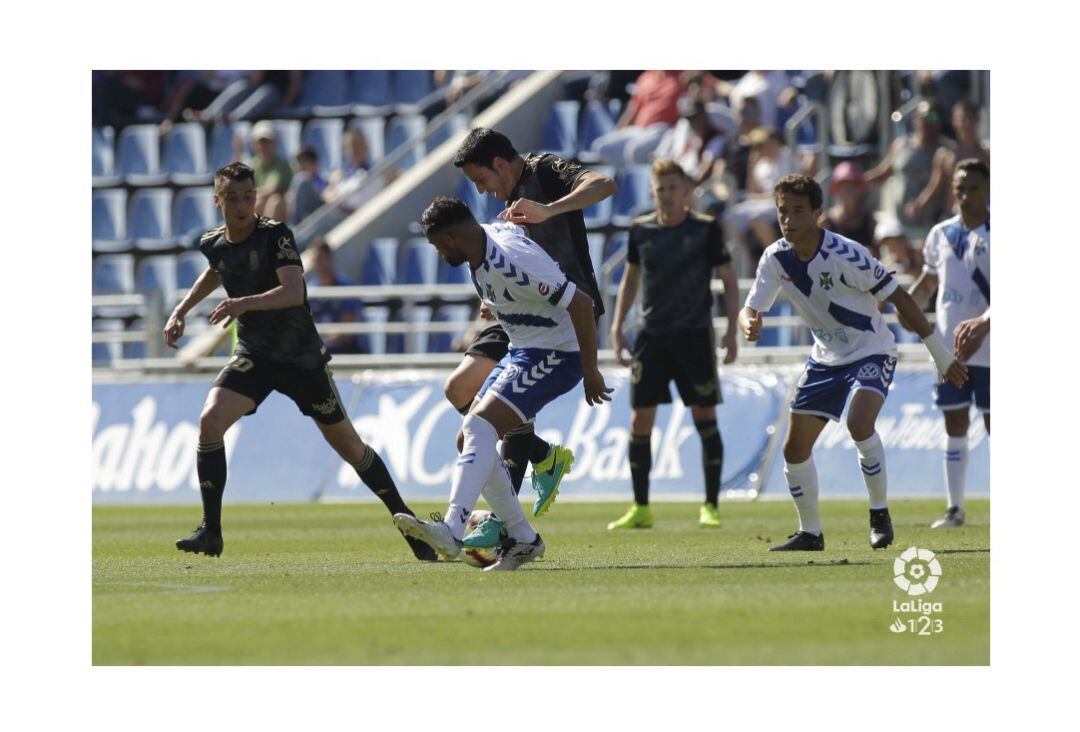 Folch conduce el balón ante la presencia de dos jugadores del Tenerife.