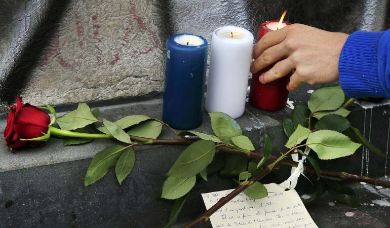 Flores y velas con los colores nacionales franceses cerca de la sala de conciertos &#039;Bataclan&#039; la mañana después de los ataques terroristas en París.