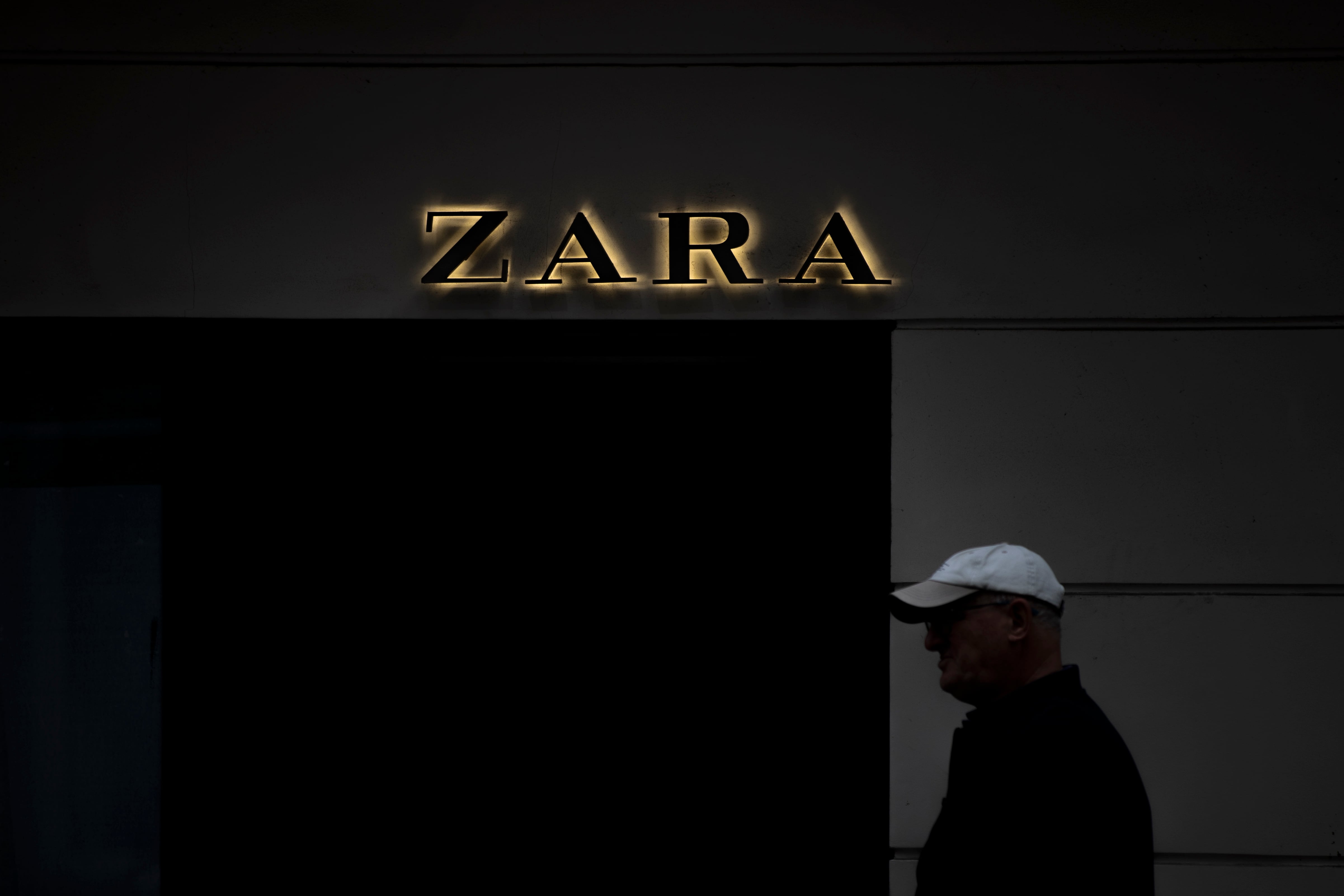 A CORUÑA, 31/03/23.- Un hombre camina por delante de un letrero de una tienda de Zara que la multinacional textil Inditex posee entre las calles Juan Flórez y Avenida de Arteixo de A Coruña, primer emplazamiento de la compañía fundada en 1975 por Amancio Ortega. Inditex cumple mañana, sábado, un año desde que este coloso de la moda comenzase una nueva etapa capitaneada por Marta Ortega como presidenta no ejecutiva, la mujer que ha logrado en poco tiempo estampar su sello tras una transición tranquila pero con resultados récord. EFE/Cabalar
