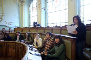 Intervención de la representante de las asociaciones de vecinos detrás de los escaños de Valladolid Toma La Palabra y Sí Se Puede