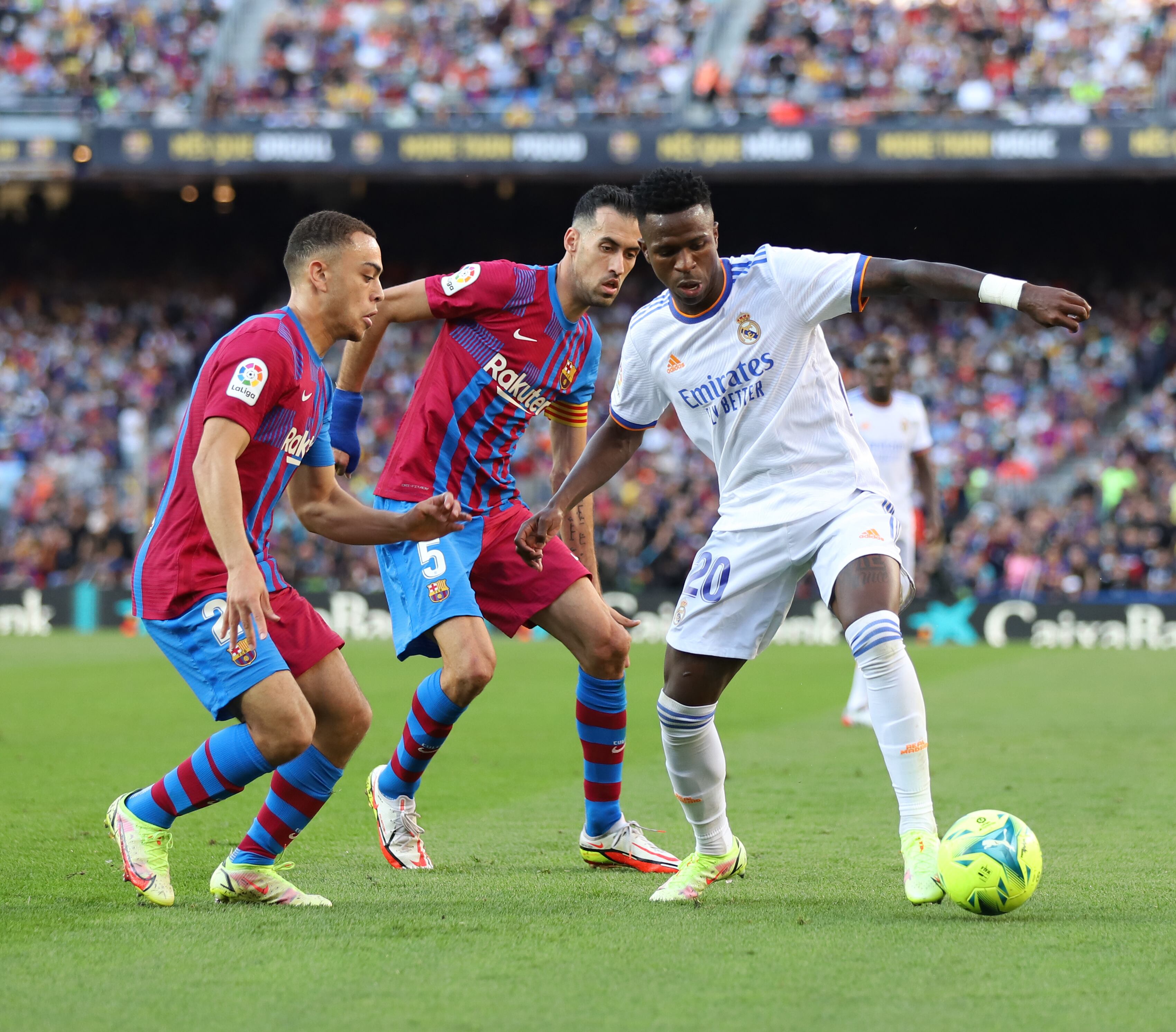 Sergiño Dest y Sergio Busquets presionan a Vinícius Junior en el anterior Clásico