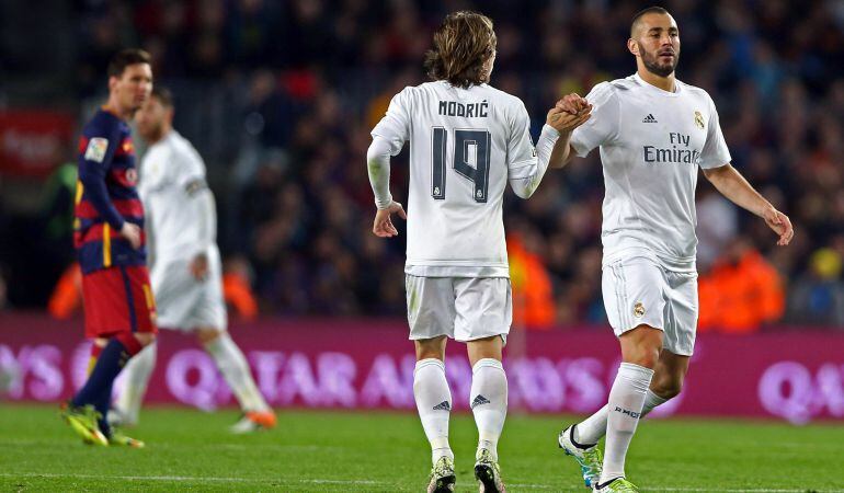 Modric y Benzema se saludan ante la mirada de Messi en el último Clásico