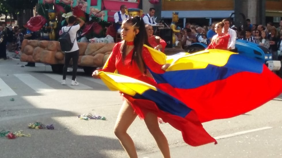 Una mujer baila envuelta en la bandera de Venezuela, en el desfile del Día de América en Asturias, en Oviedo.