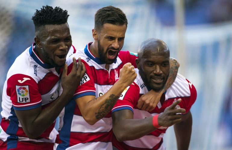 El defensa francés del Granada Jean Sylvain Babin (d) celebra con sus compañeros, Isaac Success (i) y Javi Márquez (c), el gol marcado ante el Espanyol, el primero del equipo, durante el partido de la décima jornada de Liga que disputan en el estadio Cornellà-El Prat. 