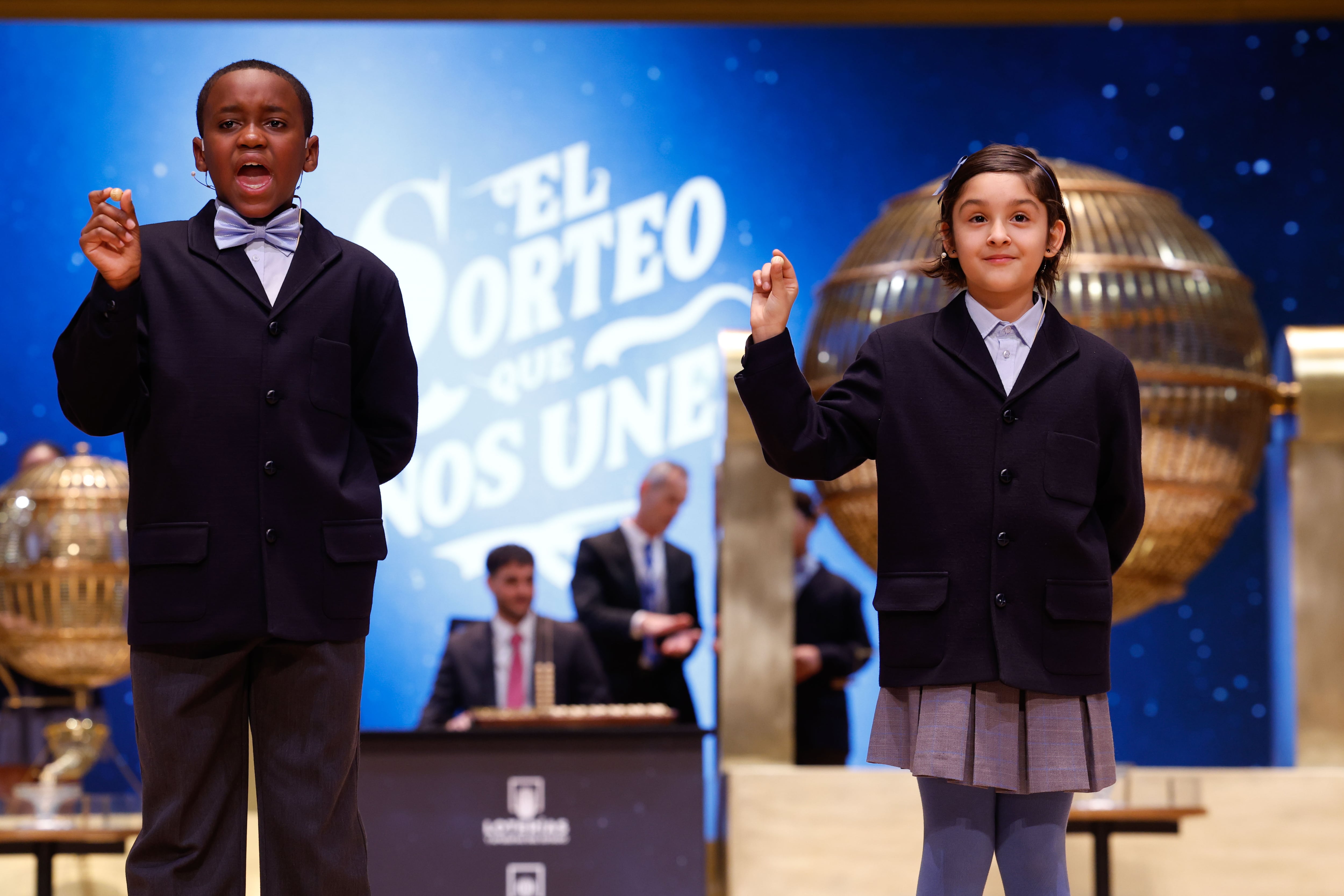 MADRID, 22/12/2024.- Los niños de la Residencia San Ildefonso de Madrid Ángel Abaga (i) y Aurora Rodríguez (d) muestran el número 74778, otro quinto premio dotado con 60.000 euros a la serie, durante el sorteo de la Lotería de Navidad que se celebra este domingo en el Teatro Real, en Madrid. EFE/Javier Lizón
