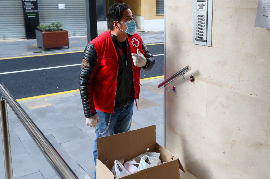 Un voluntario de Cruz Roja reparte comida a domicilio a personas vulnerables durante el confinamiento por la crisis sanitaria de coronavirus en València. 