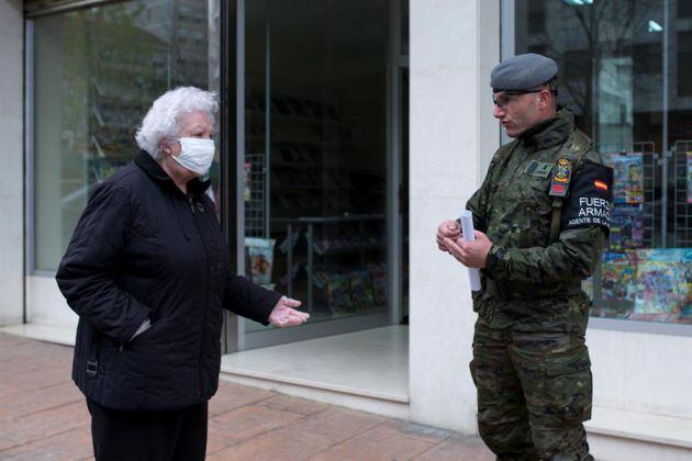 Miembro del Ejercito de Tierra en la calle junto a una vecina