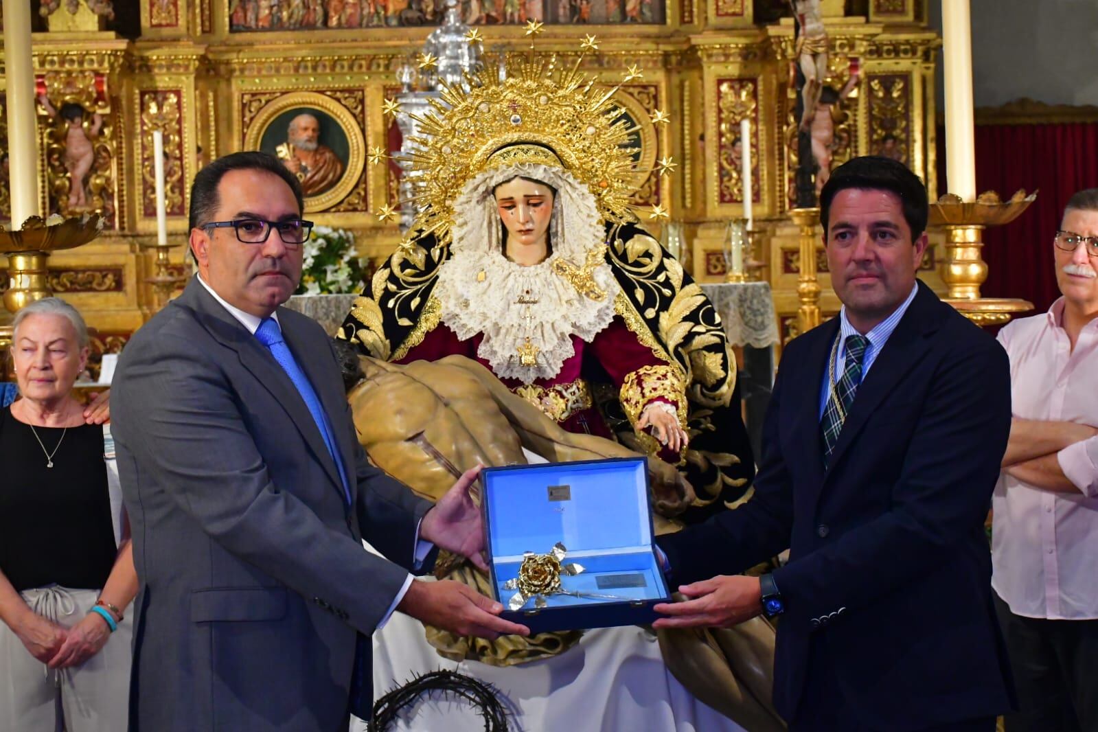 El hermano mayor del Baratillo, Luis Fernando Rodríguez -a la derecha- recibe la Rosa de Pasión de Cruz de Guía a los Donantes de Órganos de manos de Francisco Pérez Rengel, comisario de los actos del IV Centenario de la Virgen de Consolación de Osuna