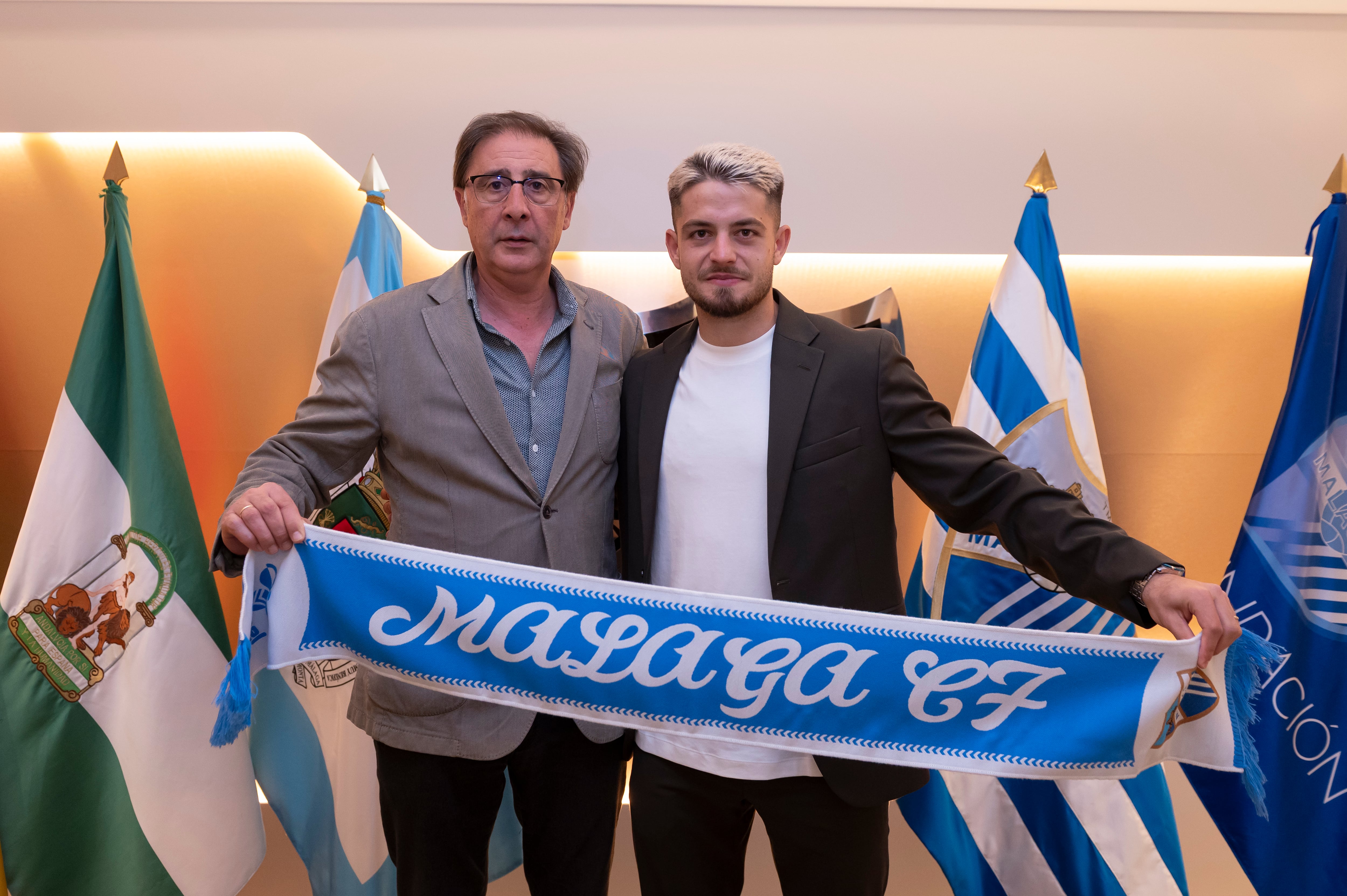 Dani Lorenzo, junto al director deportivo del Málaga, Loren Juarros, tras firmar la renovación