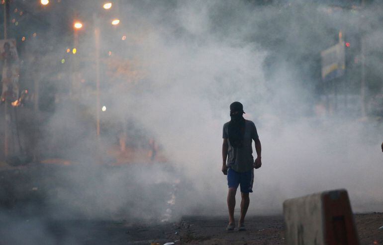 Un partidario del candidato Salvador Nasralla camina por una calle de Villanueva, Tegucigalpa durante las protestas por el fraude electoral