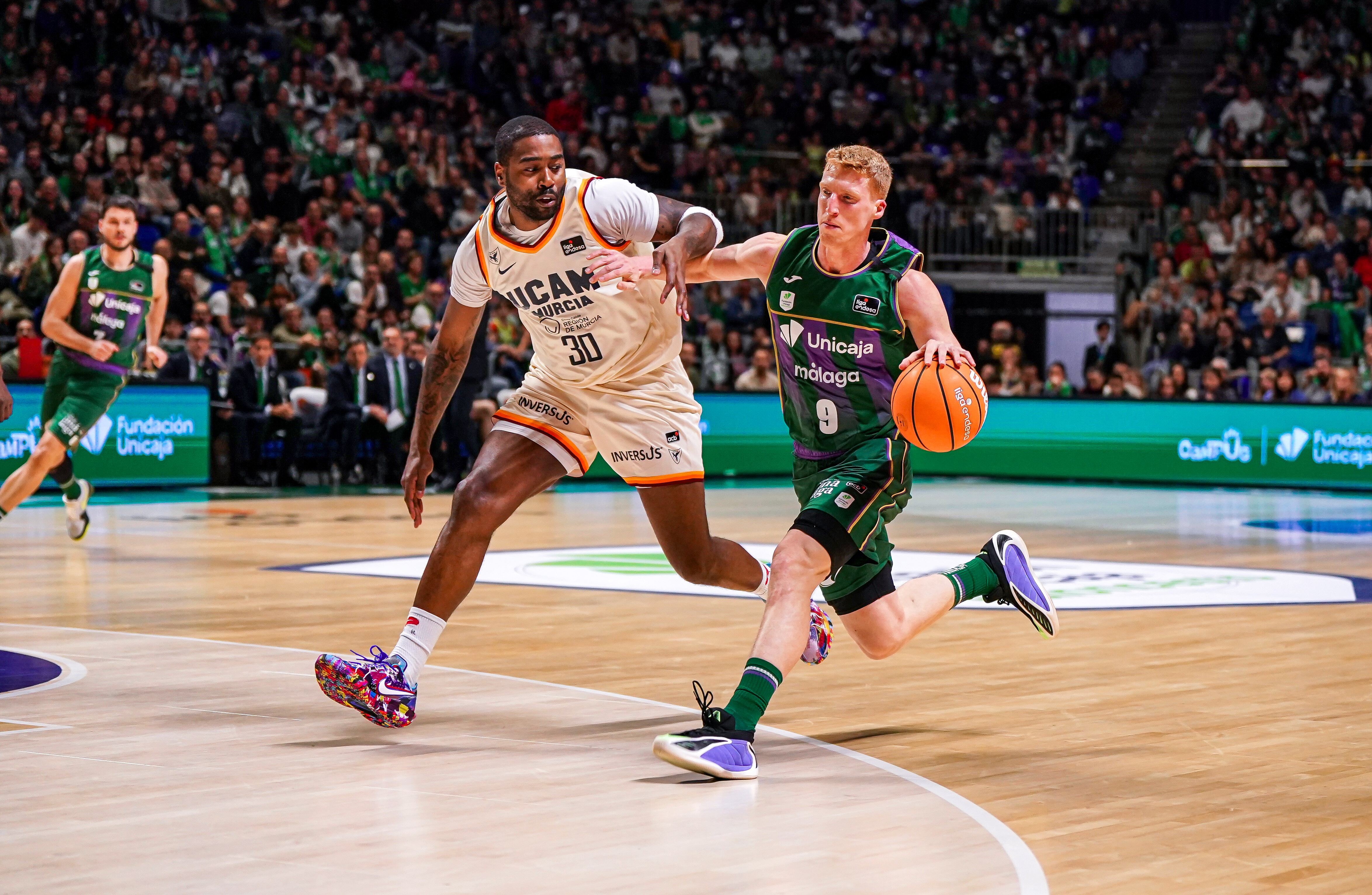 Alberto Díaz, jugador de Unicaja, atacando a Kelan Martin, jugador de UCAM Murcia, en el partido Unicaja-UCAM