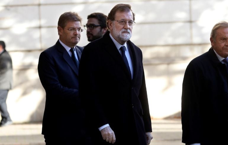 El presidente del Gobierno, Mariano Rajoy, y el ministro de Justicia, Rafael Catalá, abandonan la capilla ardiente del fiscal general del Estado, José Manuel Maza, fallecido el sábado.