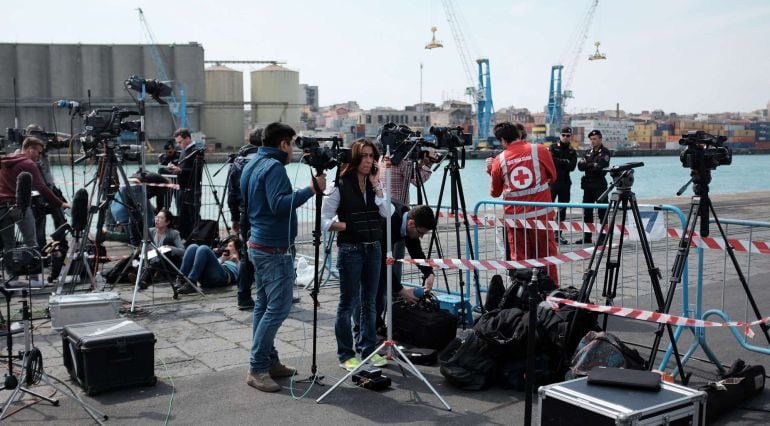 Los periodistas esperan en el puerto de Catania (Sicilia) la llegada de la patrullera que trae a los supervientes del naufragio con de un barco cargado de inmigrantes.