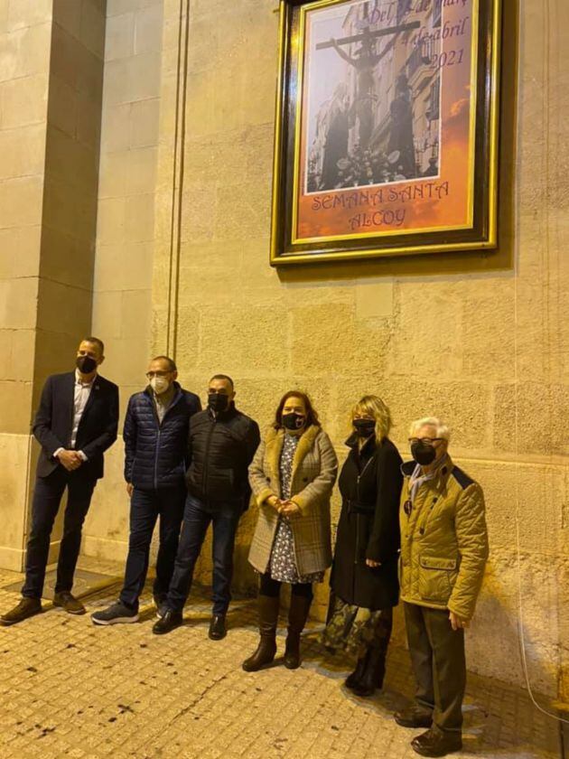 El cartel realizado por María Bolufer (en el centro de la imagen) ya anuncia la Semana Santa alcoyana de 2021.