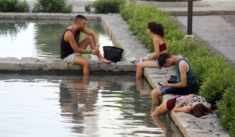 Unos jóvenes se refrescan en una de las fuentes del centro de Córdoba.