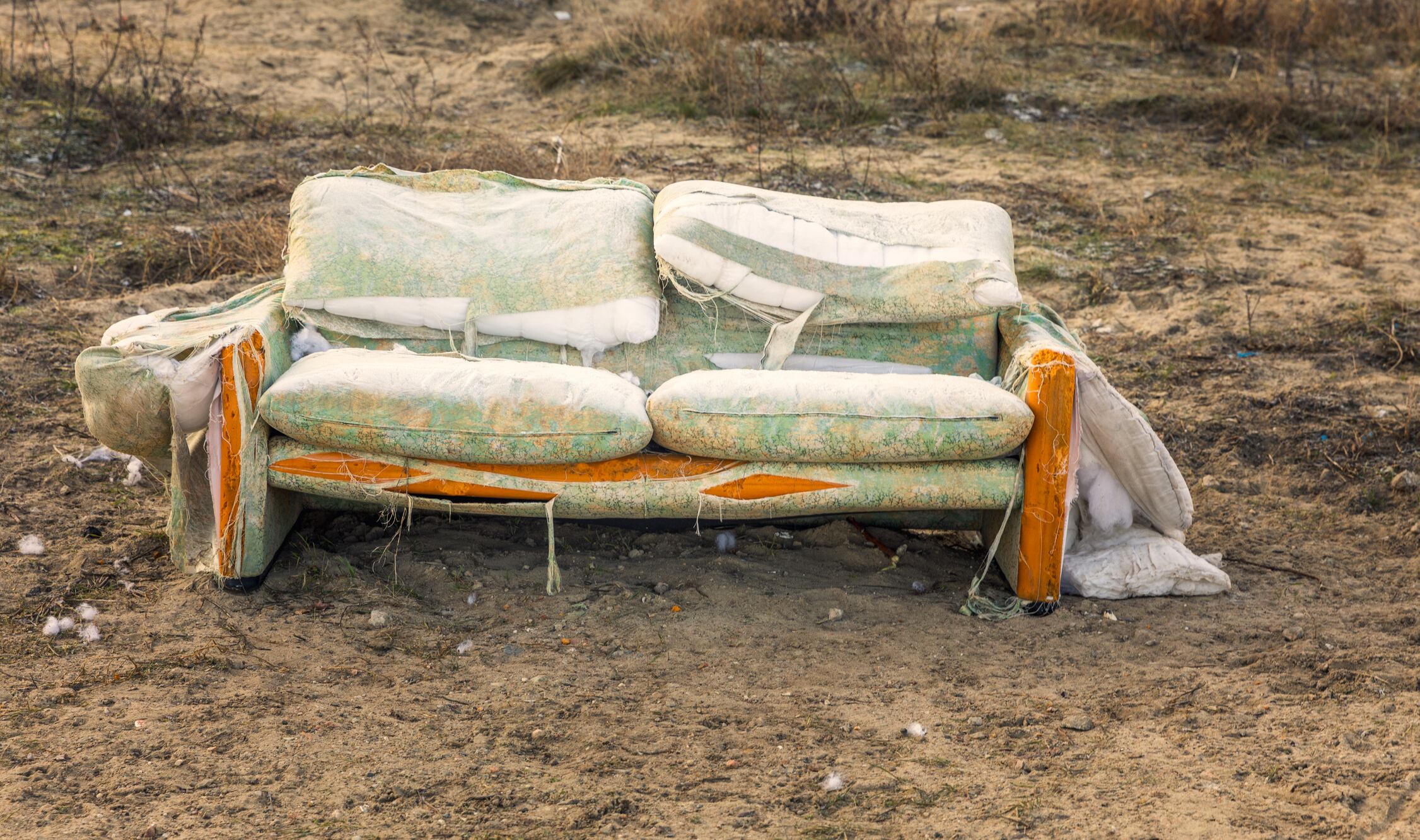 Un sofá viejo y roto en un solar abandonado