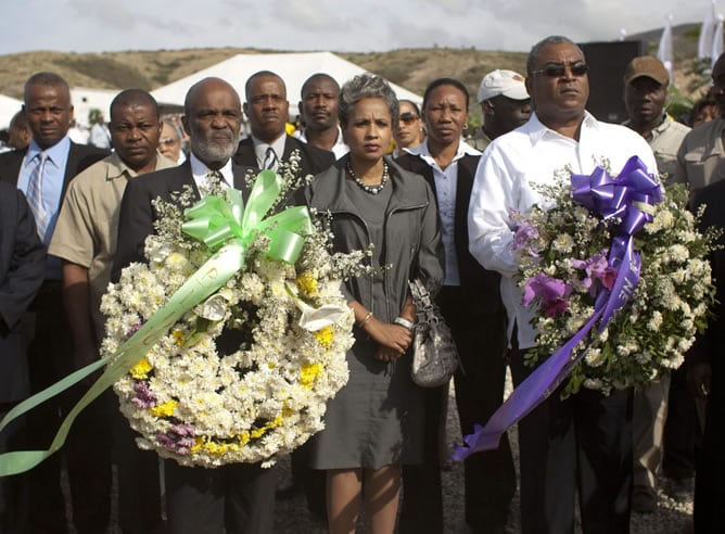 El presidente de Haití, René Preval (i); su esposa, Elisabeth Preval (c); y el primer ministro Jean Max Bellerive (d), portan coronas de flores durante un homenaje celebrado en St Christophe, Titanyen, a las afueras de Puerto Príncipe (Haití), zona donde 