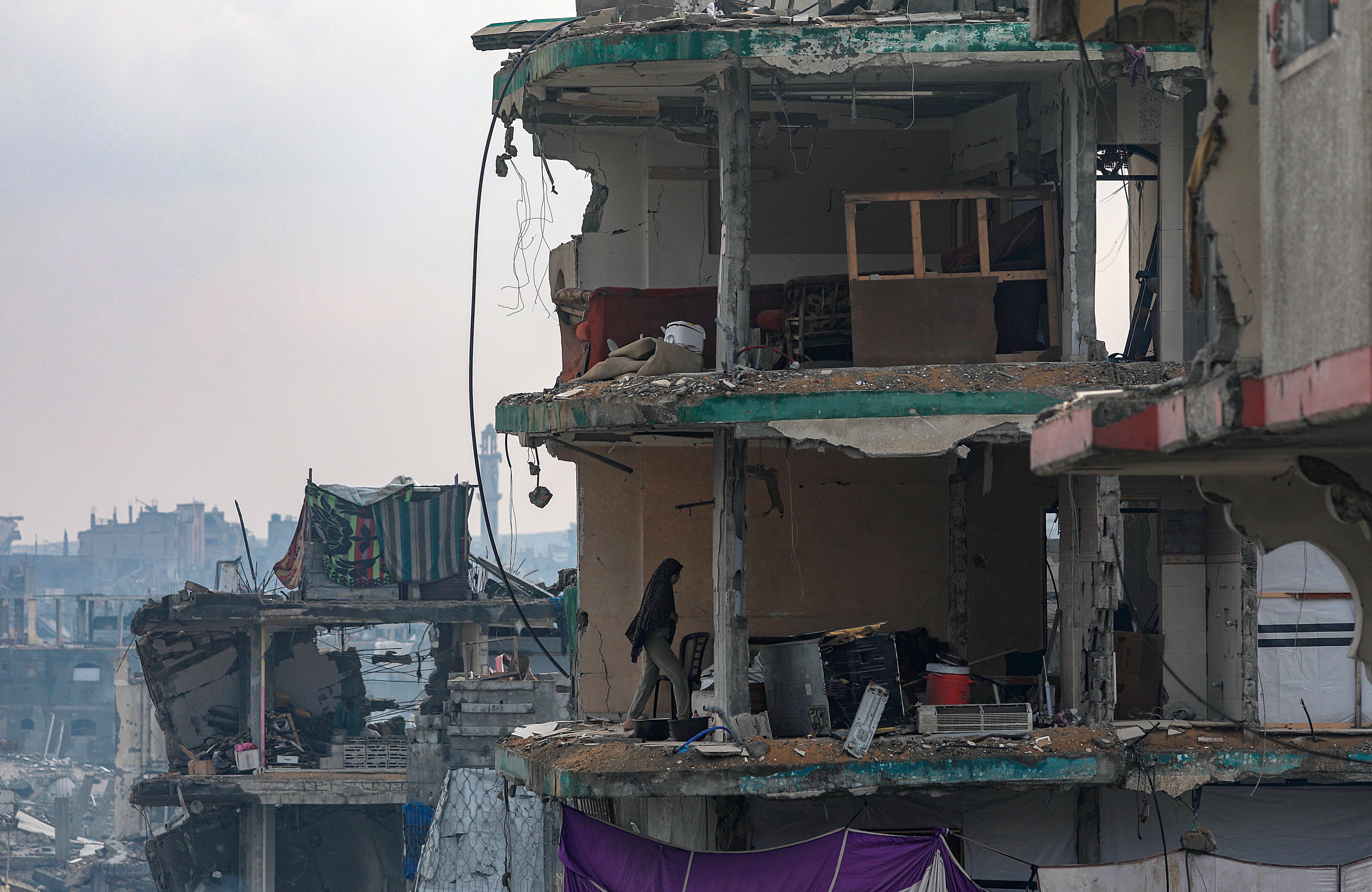Una mujer palestina camina por su casa familiar destruida en el barrio de Sheikh Radwan, en la ciudad de Gaza, Franja de Gaza, el 14 de noviembre de 2025, en medio de un alto el fuego entre Israel y Hamás.