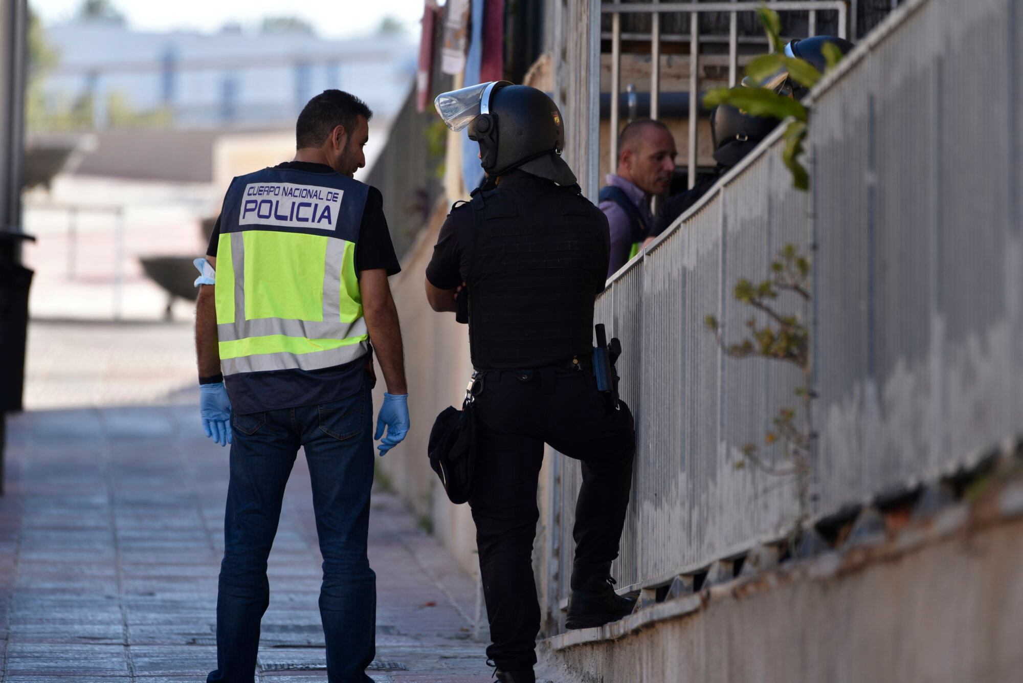 Dos agentes de la Policía Nacional durante un dispositivo en el marco de un operativo vinculado al Área de Extranjería, en la barriada Loma Colmenar de Ceuta.