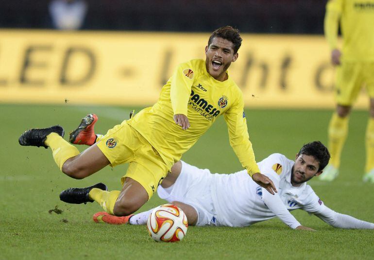 El jugador del Zúrich,Oliver Buff lucha por el balón con el delantero mexicano Jonathan Dos Santos del Villarreal.