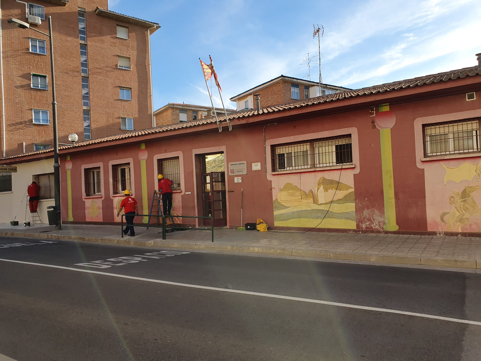 Trabajadores de Carinsertas pintando la fachada del albergue