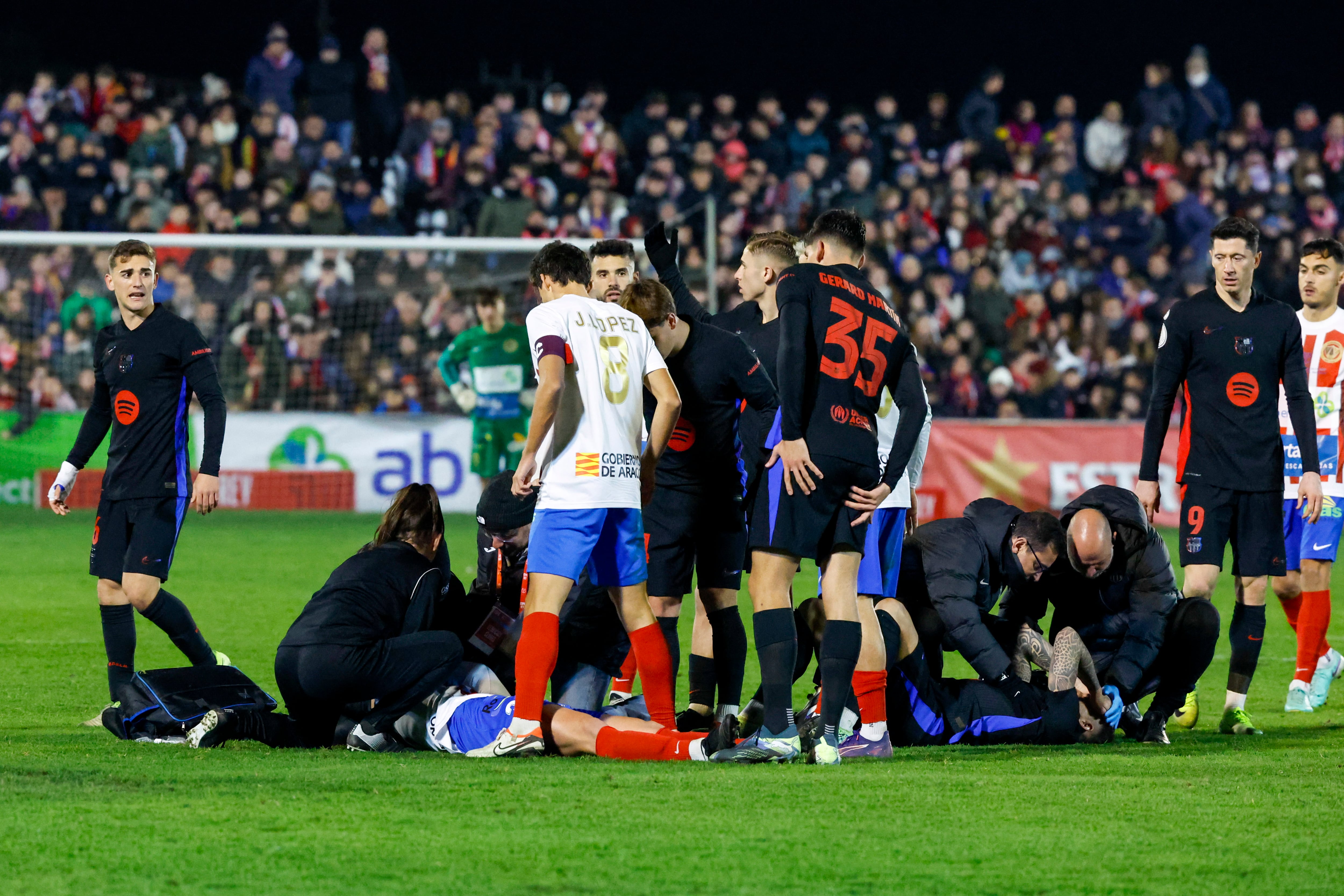 BARBASTRO (HUESCA), 04/01/2025.-El defensa del Barcelona Íñigo Martínez, y el centrocampista del Barbastro Jaime Ara, ambos en el suelo durante el partido de dieciseisavos de la Copa del Rey, este sábado en el Campo Municipal de Deportes de Barbastro.-EFE/ Javier Cebollada
