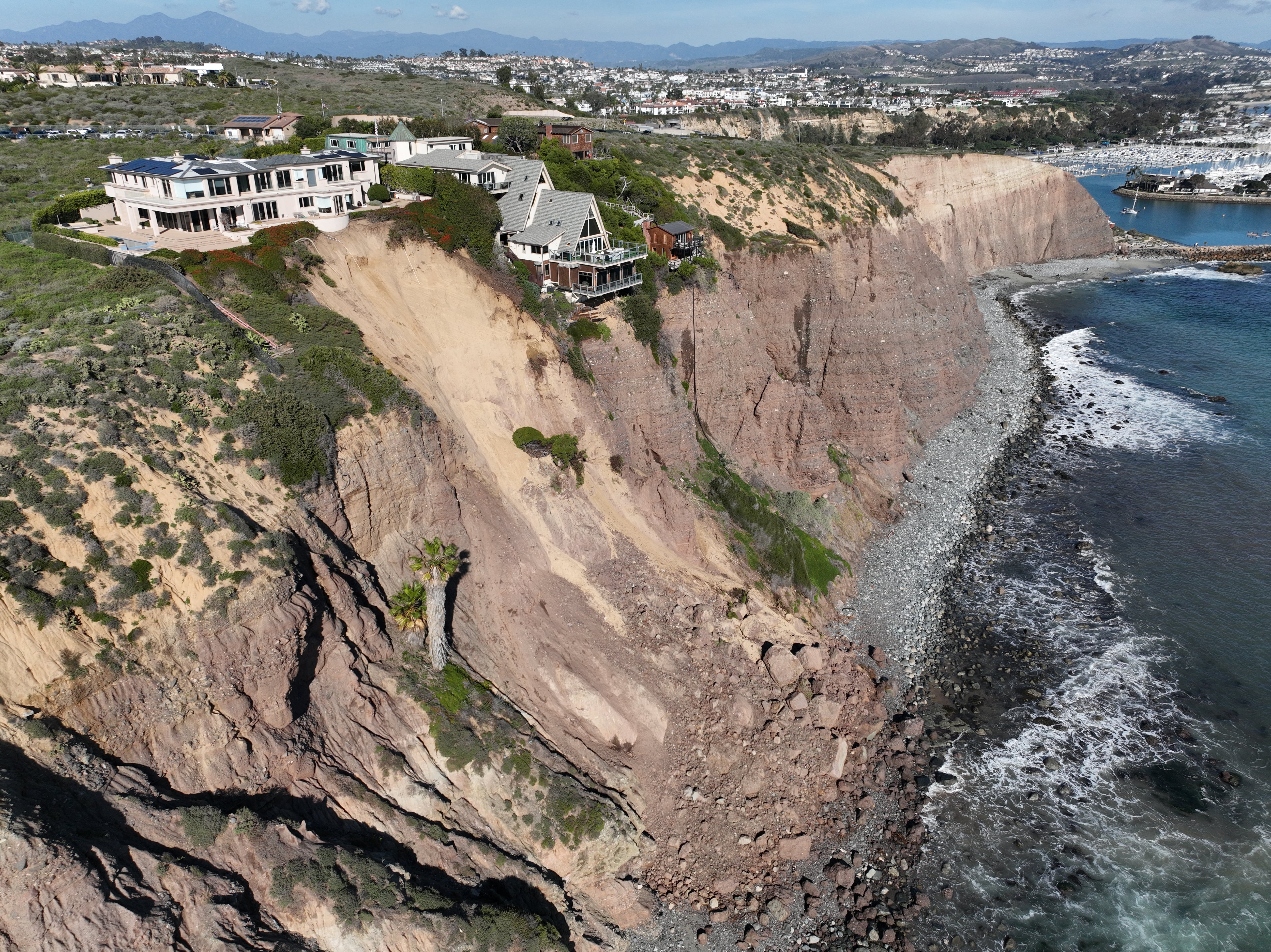 An aerial view of three large homes in Dana Point are in danger of falling into the ocean after a cliffside gave way over the weekend after recent heavy rains in Dana Point Tuesday, Feb. 13, 2024.