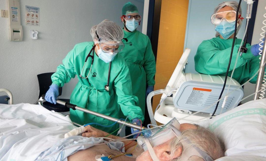 Tres profesionales sanitarios atienden a un enfermo.