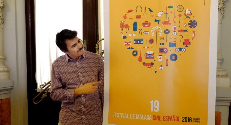 El autor del cartel, Armando Jiménez, junto a su creación 