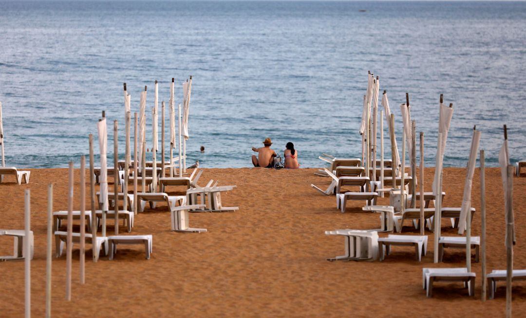A couple is seen next to empty hammocks during the coronavirus disease (COVID-19) pandemic in downtown Albufeira, Portugal July 20, 2020. Picture taken July 20, 2020. REUTERS Rafael Marchante