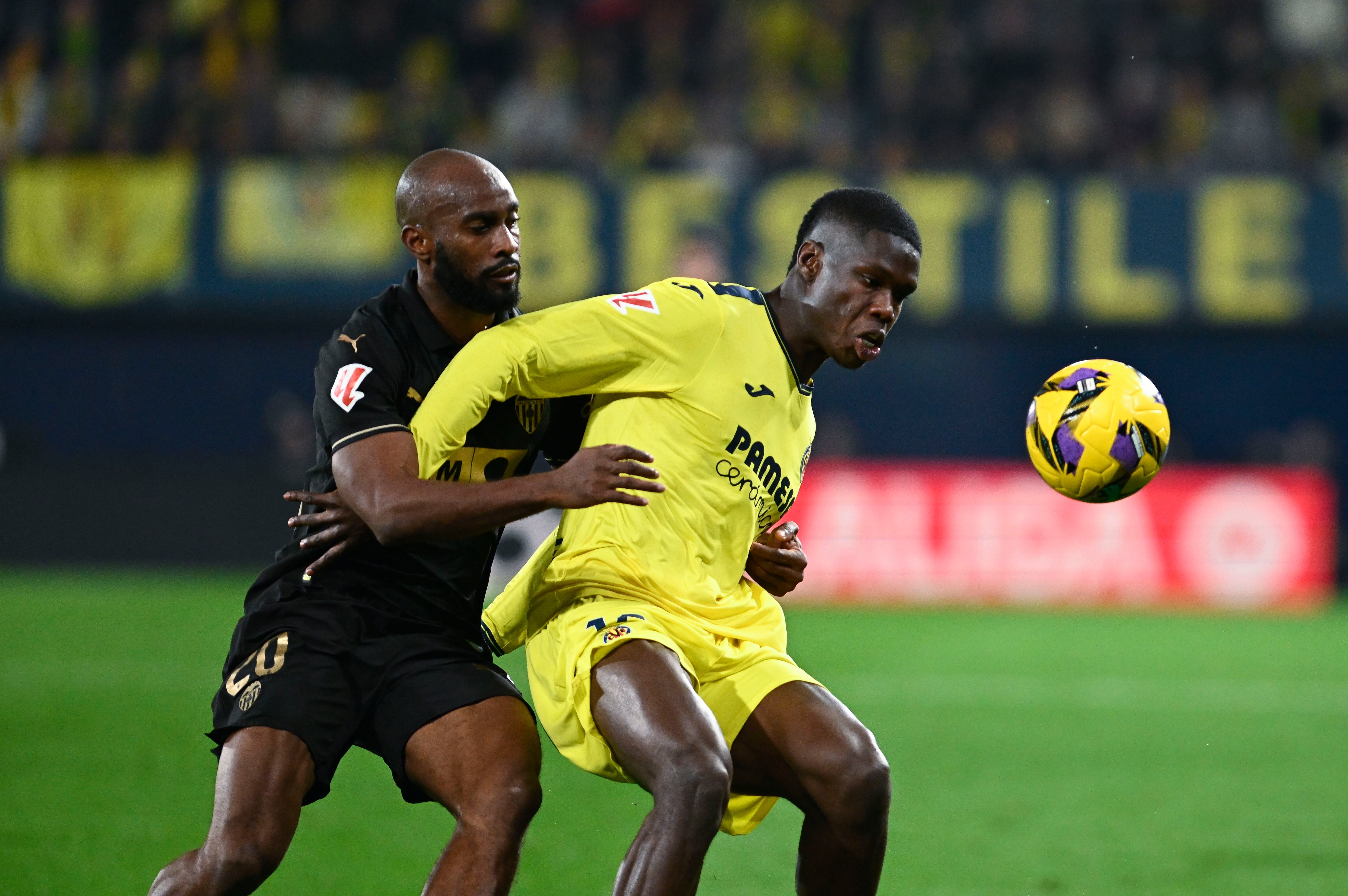 VILLARREAL, 15/02/2025.- El defensa del Valencia Dimitri Foulquier (i) lucha con Thierno Barry (d), del Villarreal, durante el partido de la jornada 24 de LaLiga entre el Villarreal CF y el Valencia CF, este sábado en el estadio de la Cerámica.- EFE/ Andreu Esteban
