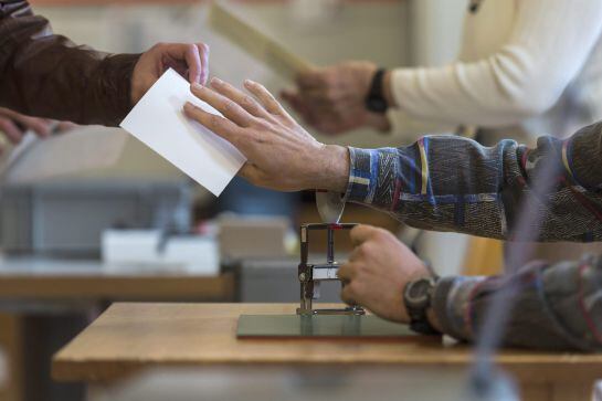 Los votantes suizos acuden a votar en un colegio electoral de Berna.