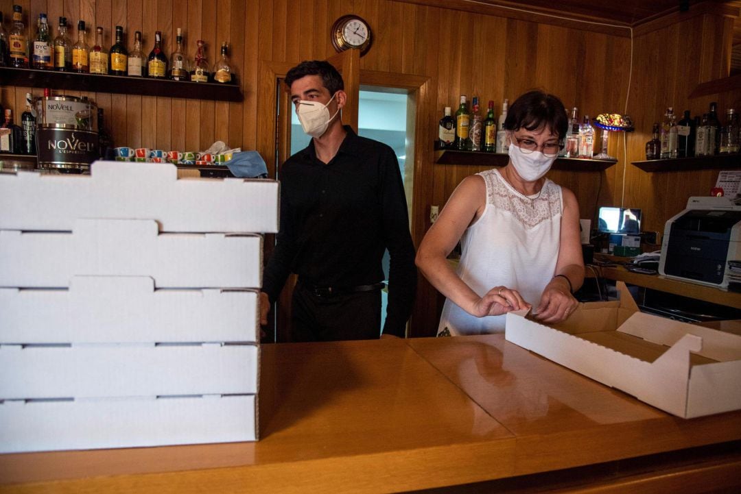 Dos camareros preparan cajas de comida para llevar tras conocerse que la Generalitat aplicará a partir de esta medianoche un confinamiento domiciliario parcial a los habitantes de Lleida 