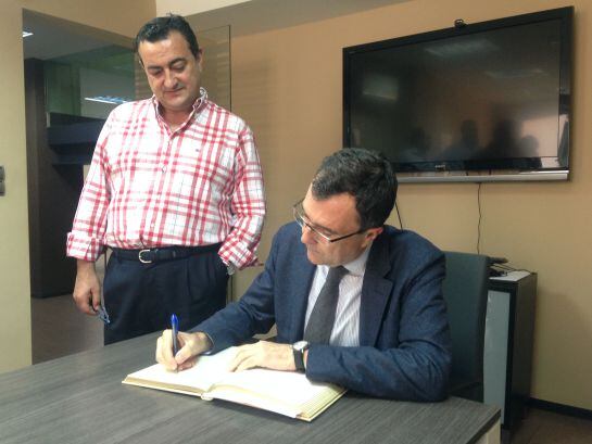 El Alcalde de Murcia, José ballesta, firmando el libro de honor de Radio Murcia bajo la mirada del Director de la emisora Domingo Camacho.