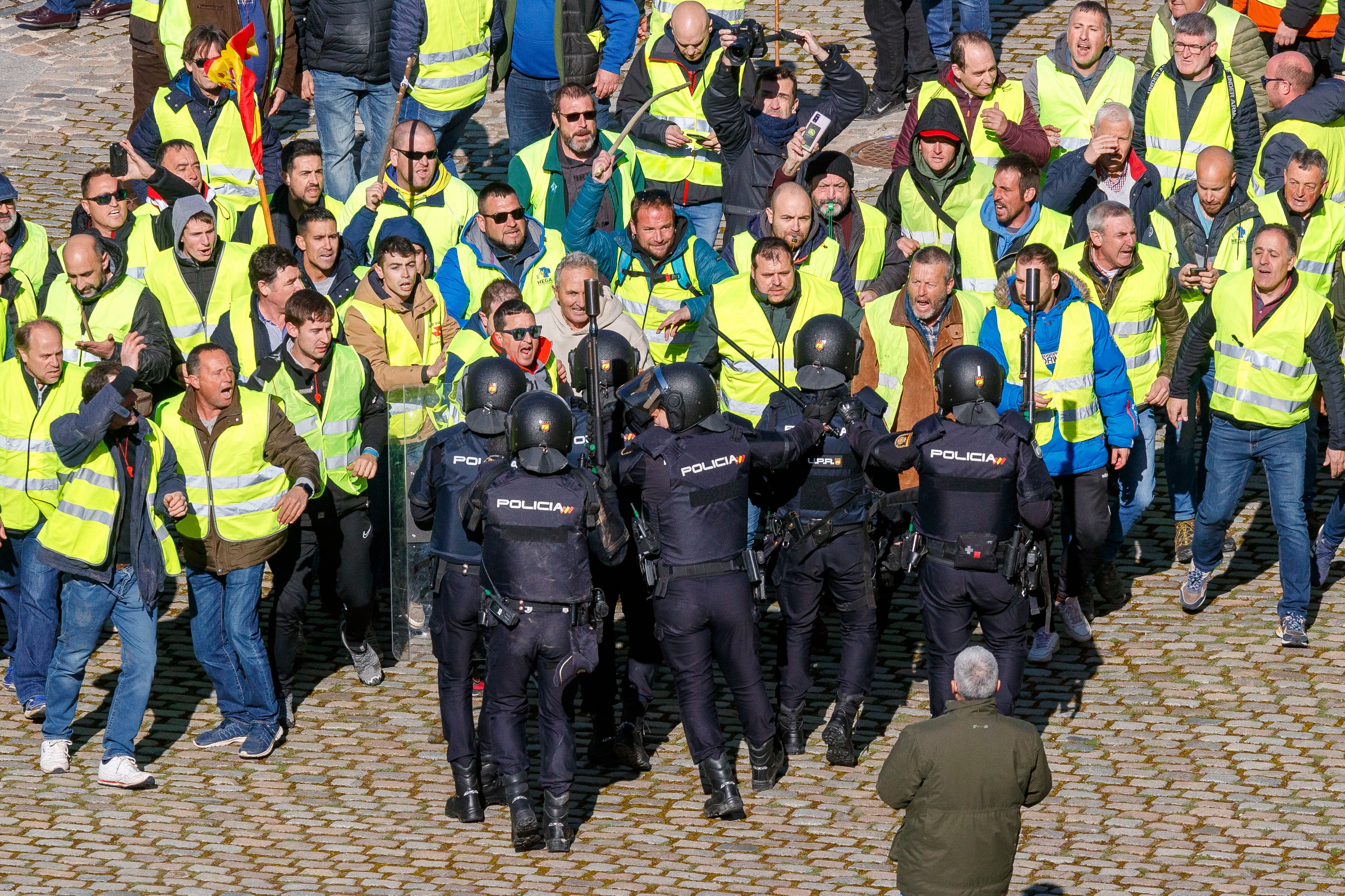 ZARAGOZA, 01/03/2024.- Un grupo de agricultores intenta romper el cordón policial mientras se concentran en los alrededores del Palacio de La Aljafería, sede de las Cortes de Aragón, este viernes en Zaragoza. EFE/ Javier Belver
