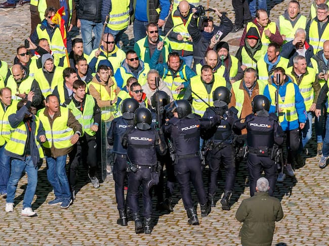ZARAGOZA, 01/03/2024.- Un grupo de agricultores intenta romper el cordón policial mientras se concentran en los alrededores del Palacio de La Aljafería, sede de las Cortes de Aragón, este viernes en Zaragoza. EFE/ Javier Belver